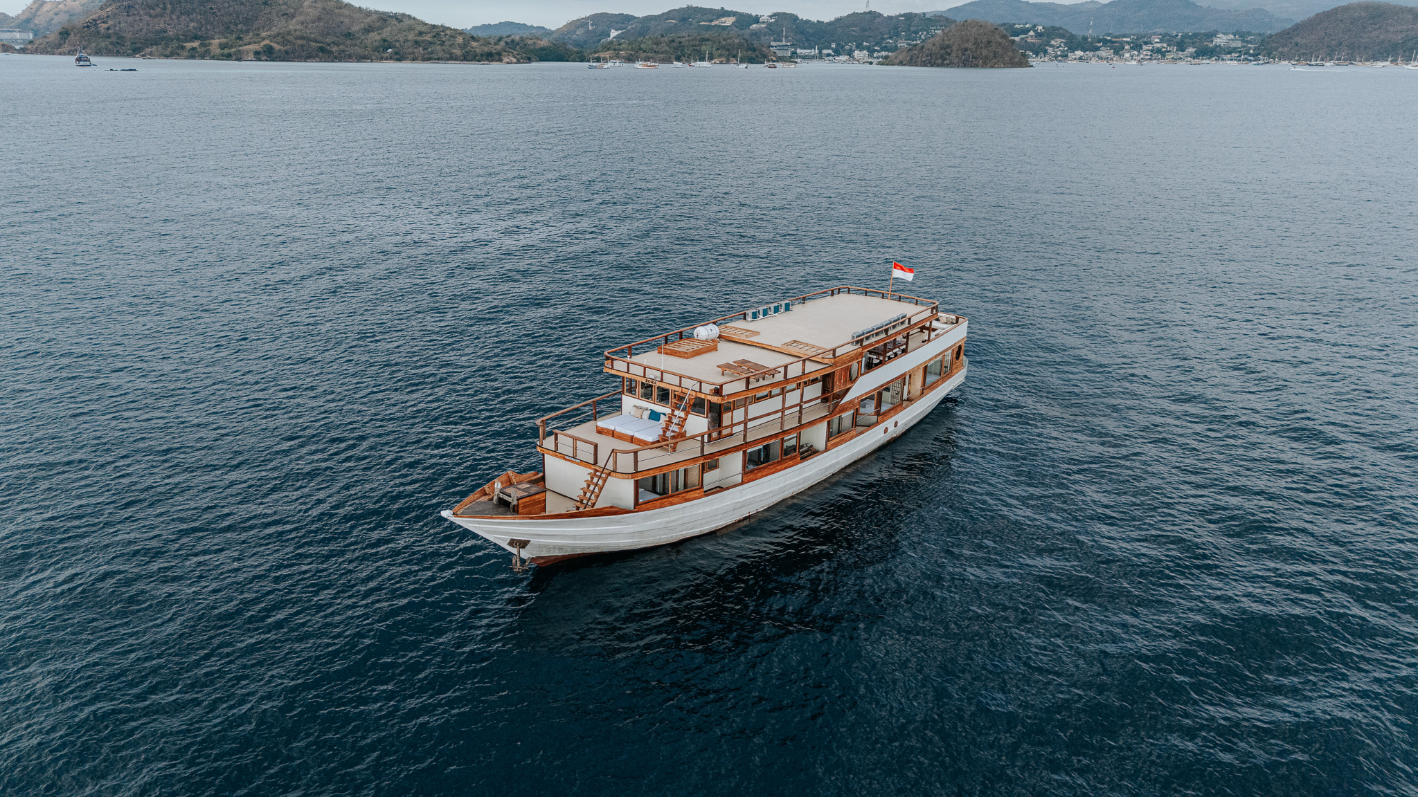 Sora Komodo Liveaboard luxury phinisi cruising through turquoise waters of Komodo National Park