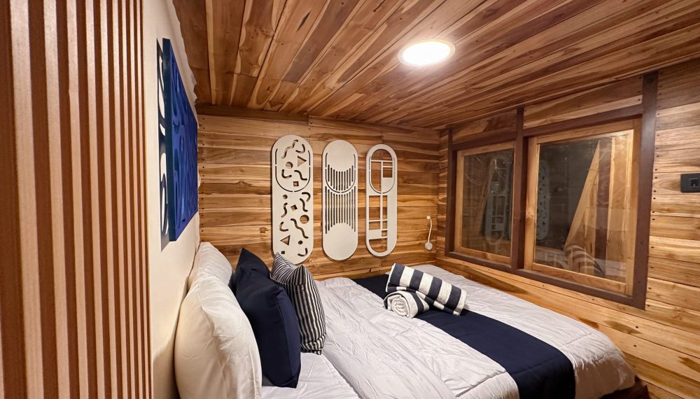 Azure room on Vhalé Liveaboard with natural wood finish and elegant décor and sharing bathroom